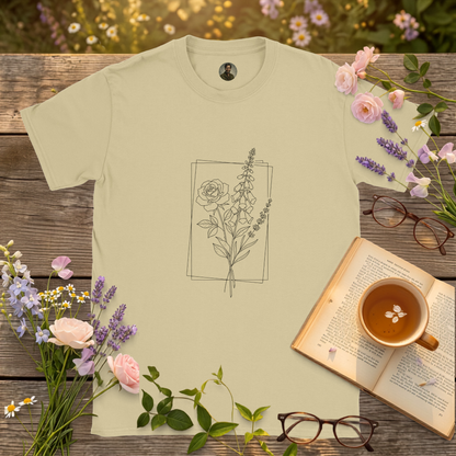 natural colour t-shirt on a picnic table surrounded by flowers, a book and a cup of tea