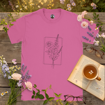 pink colour t-shirt on a picnic table surrounded by flowers, a book and a cup of tea
