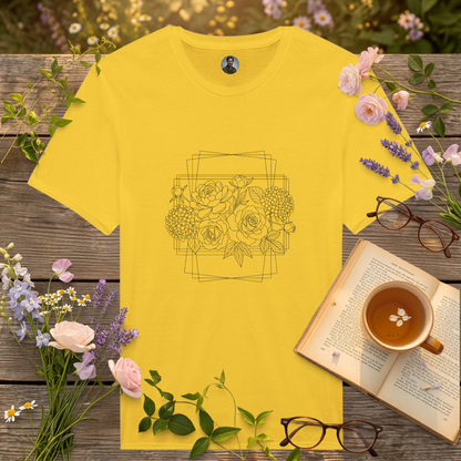 yellow coloured t-shirt on a picnic table surrounded by flowers, a book and a cup of tea