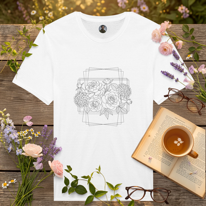 white t-shirt on a picnic table surrounded by flowers, a book and a cup of tea